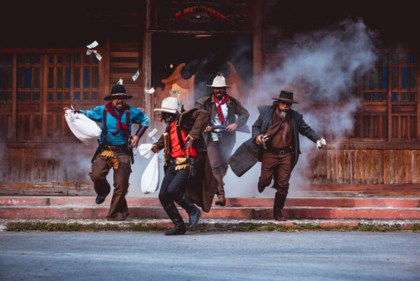 Cowboys group showing action success bank rob with fighting gun and a lot of money from rob the bank with white smoke vintage style background.