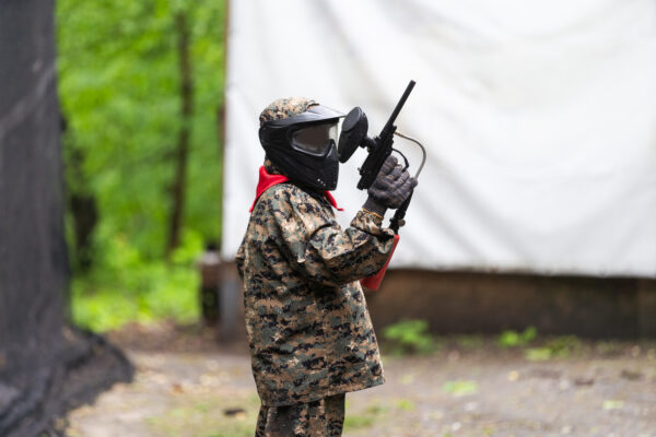 children playing paintball in the forest. High quality photo